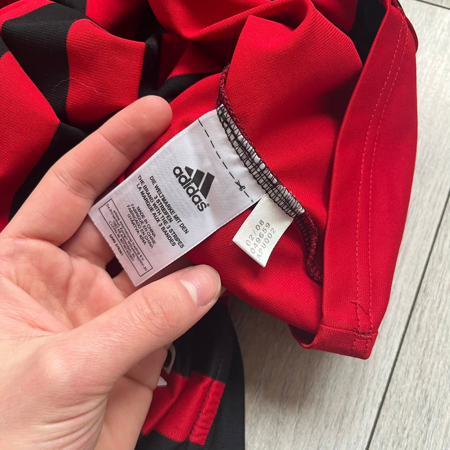 AC Milan Academy x Dolce & Gabbana 2008/09 Home Tee is a black and red striped football shirt with black short sleeves. The chest features AC Milan Academy and Dolce & Gabbana Junior logos on the sides, and a adidas logo in the center. Made with Clima365 technology.