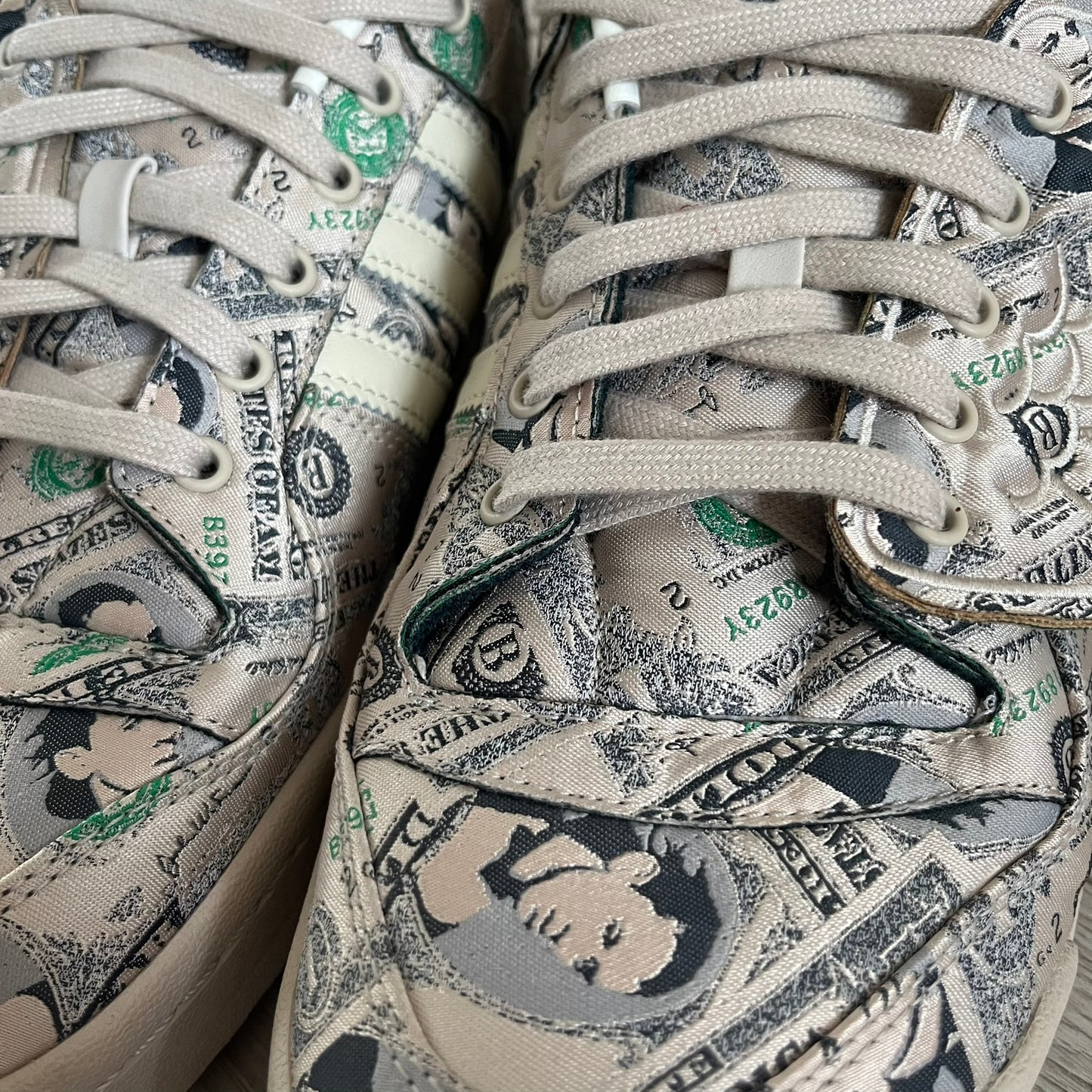 Adidas Jeremy Scott x Forum Wings 1.0 Low Money, style GX6393, in a Bliss/Off White/Bliss colorway. This pair features a textile upper covered in Jeremy Scott’s signature currency-themed graphic, swapping George Washington’s portrait for his own. The iconic 3D wings sit on the side of the shoe, with embossed adidas branding and Scott’s signature on opposite panels. Built with an EVA wedge for lightweight cushioning and a durable rubber cup sole. First released on October 21, 2021.