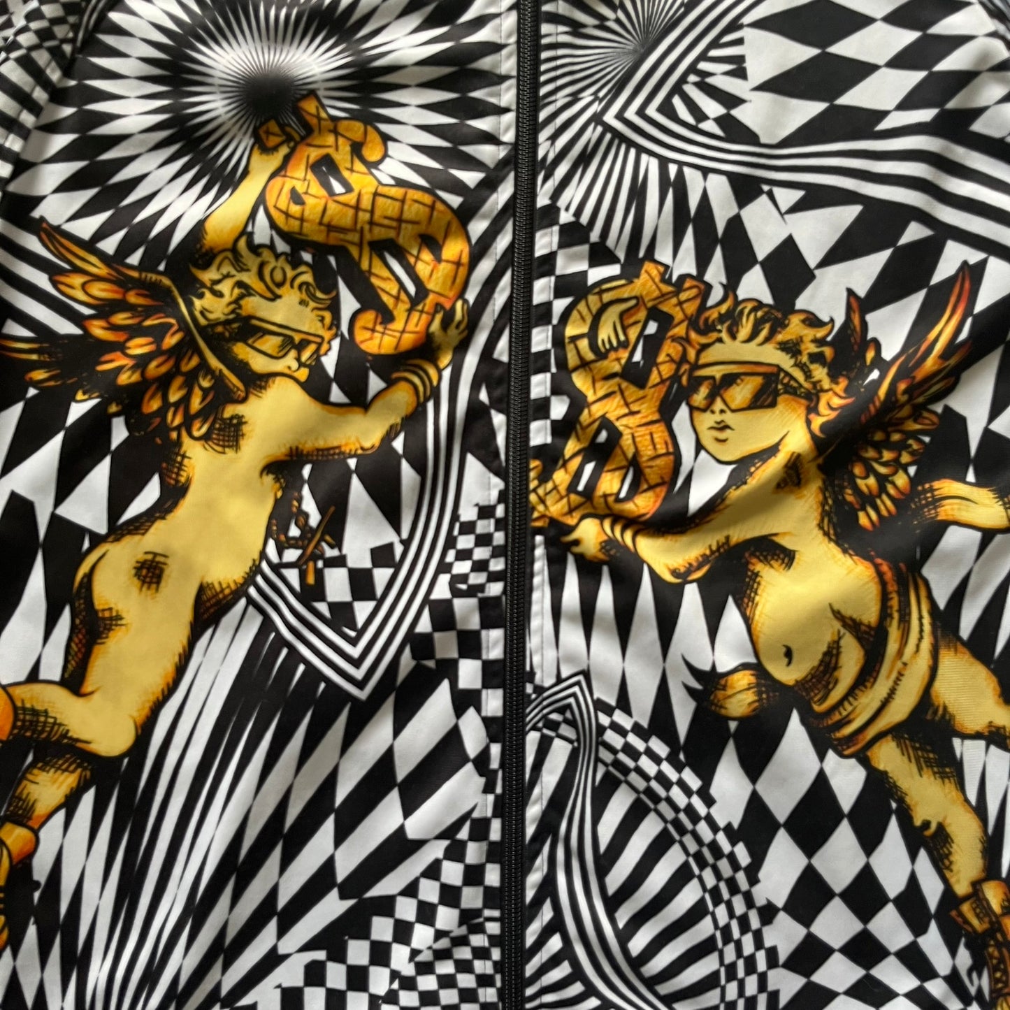 Gold cherub with wings on a black and white geometric patterned background