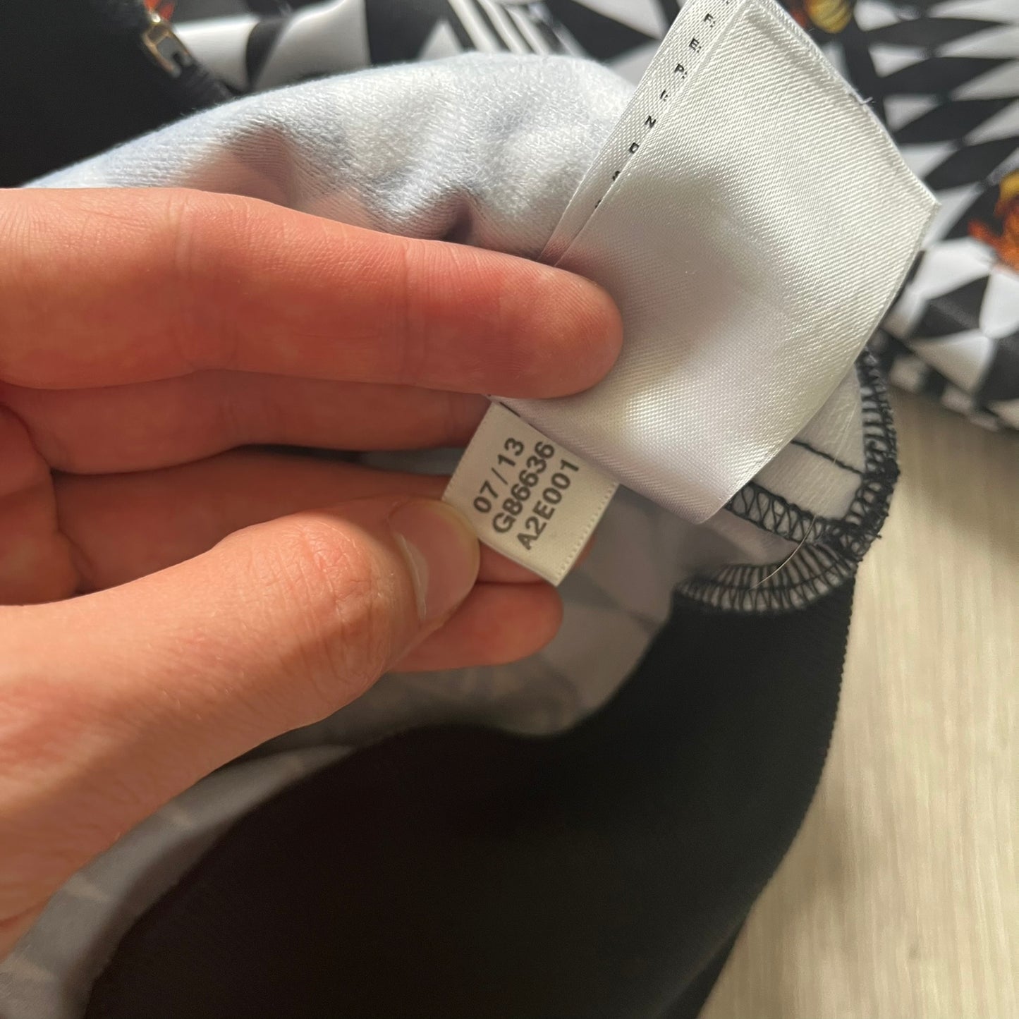 Hand holding a cap with a visible brand label on a blurred background