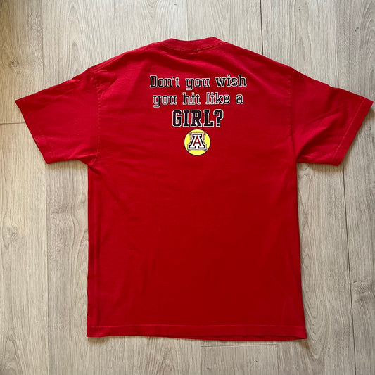 Red t-shirt with text and logo on a wooden surface