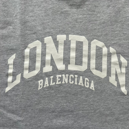 Gray t-shirt with 'London Balenciaga' text in metallic silver on a gray background