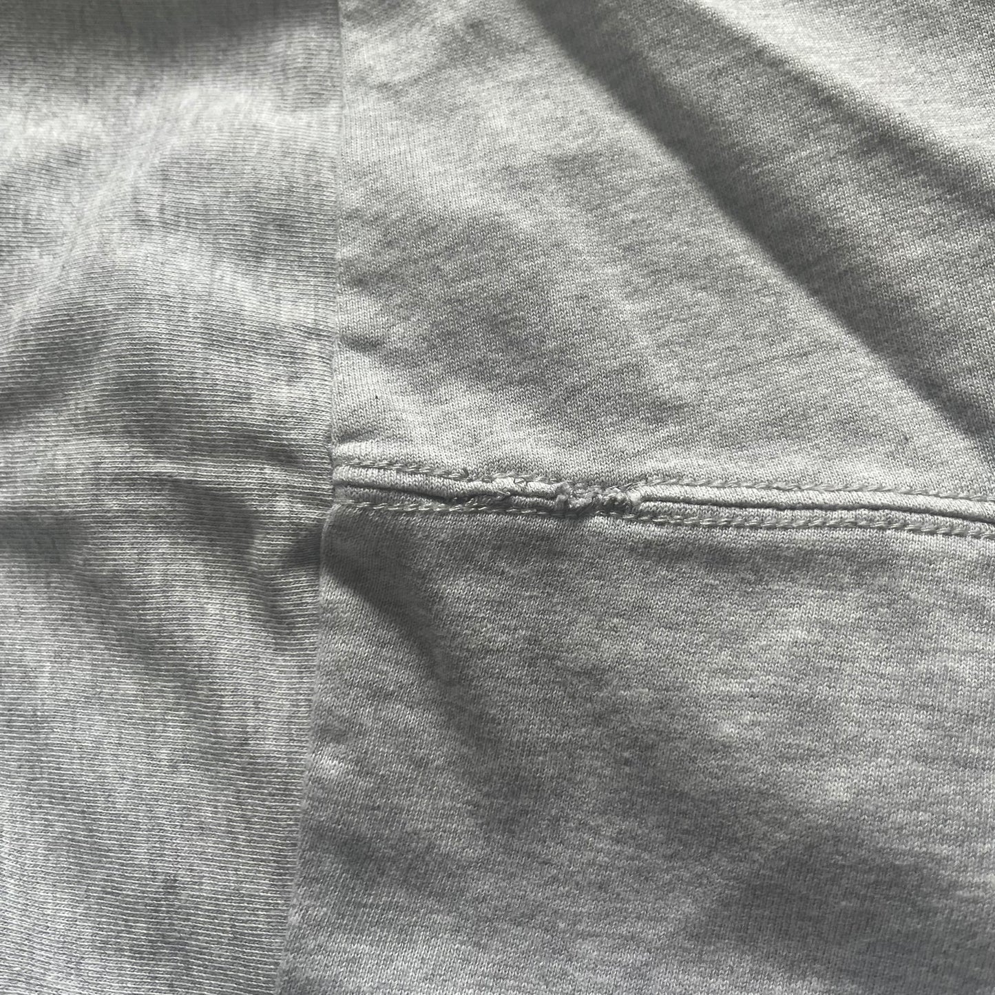 Close-up of gray fabric with a focus on texture and stitching.
