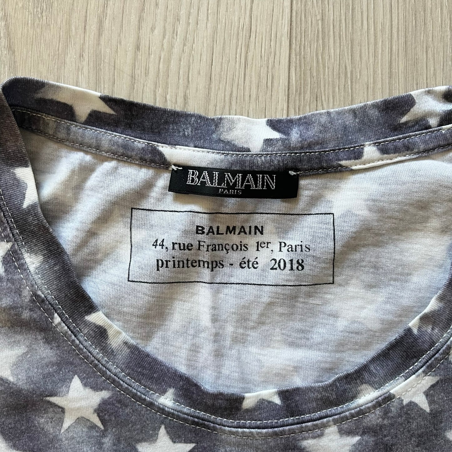 Balmain SS18 t-shirt in 100% cotton featuring a bold full-print USA flag on both sides. The front is accented with “Balmain Paris” text at the stomach, combining patriotic imagery with the brand’s signature luxury touch. A rare and powerful piece from the 2018 runway season.