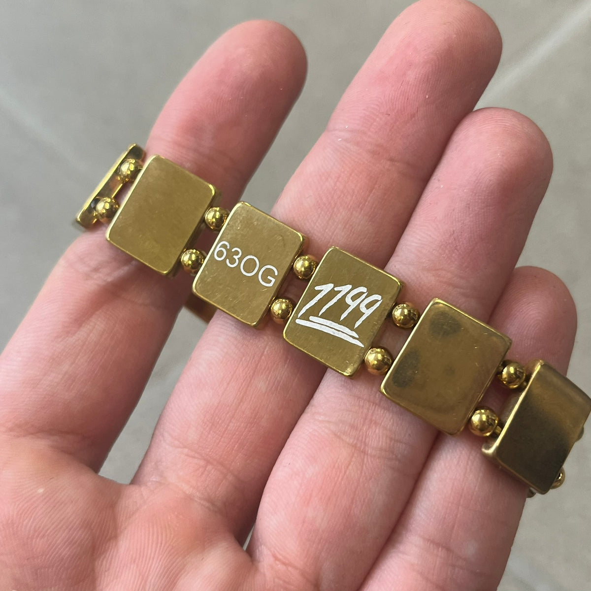 Bazo 1199 "63 OG" Stainless Steel Gold Plated Bracelet is a gold color stainless steel bracelet with thin and smooth beads. The interior is engraved with the 1199 logo and 63OG text. 
