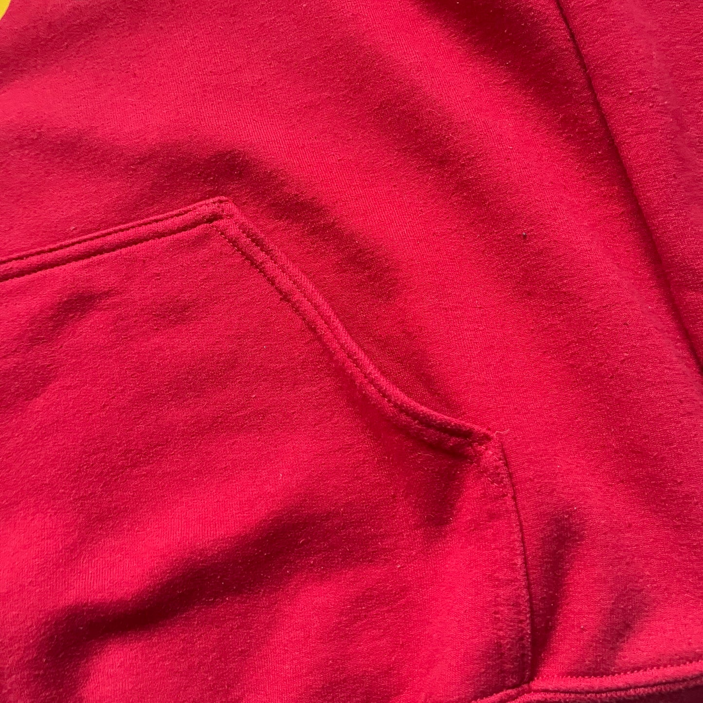 Bevar Christiania Red Hoodie is a red pullover hoodie made on a Gildan Heavy Blend blank, manufactured in Honduras. It features a classic construction with an adjustable hood and a front kangaroo pocket. The front displays yellow “Bevar Christiania” text with three large yellow dots printed underneath.