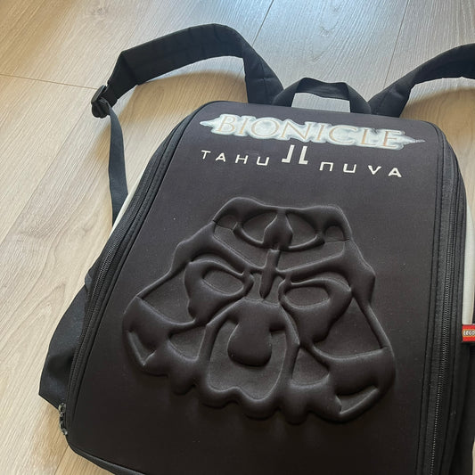 Extremely rare 2003 Bionicle Tahu Nuva backpack, produced by Kabooki for the Lego Cargo System line. The front features a large 3D molded face of Tahu Nuva, topped with a big Bionicle logo and his name underneath. Designed with one spacious main compartment and two smaller side pockets secured by velcro straps. Backpack was basically never seen online before.