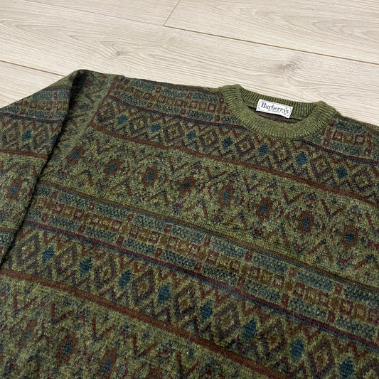 Burberry’s of London 90’s Sweater from 1998/99, crafted from a blend of acrylic, mohair, polyamide, wool, alpaca, and viscose. Features an all-over repeat pattern in green, navy, and brown tones. Vintage piece with original white Burberry tag.