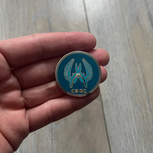 Original physical Counter-Strike: Global Offensive Series 1 Guardian pin, produced as official Valve merchandise. These pins were sold at Valve-sponsored CS:GO Major events and later through the official WeLoveFine store, and originally included a code to unlock a “Genuine” in-game digital pin on a Steam profile. This example comes complete with the original packaging; the code has been scratched and is already used.