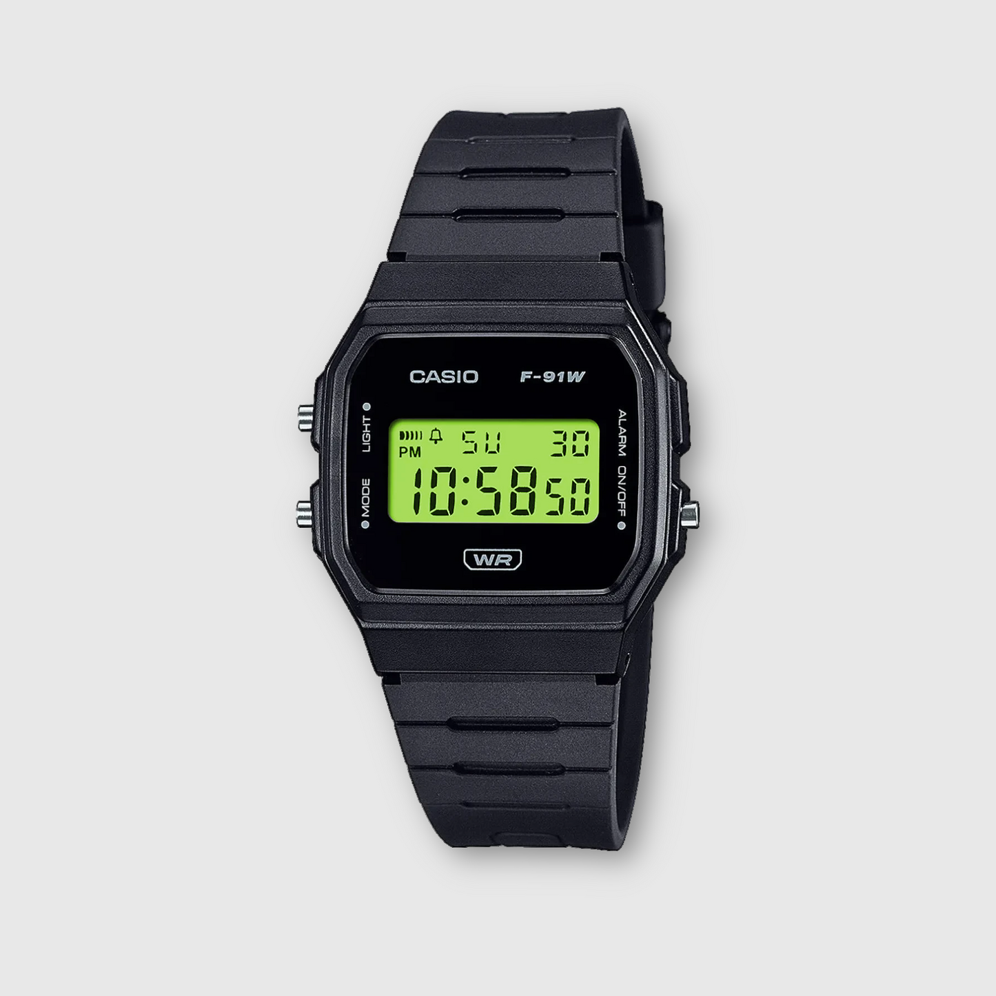 Black Casio digital watch with green display on a light gray background