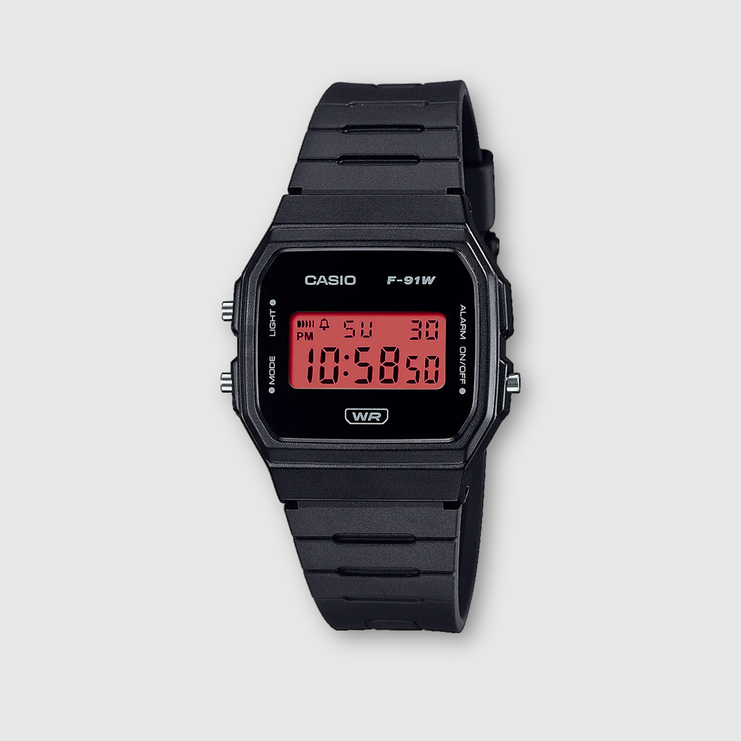 Black Casio digital watch with red display on a light gray background