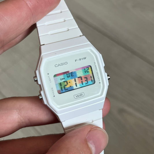 Custom Casio F-91W White digital watch featuring a Multicolor interlocking bricks filter screen. Slim 8.5 mm profile, lightweight 21 g build and flexible bio-based resin band ensure lasting comfort. Includes alarm, stopwatch, and microlight function for everyday functionality.