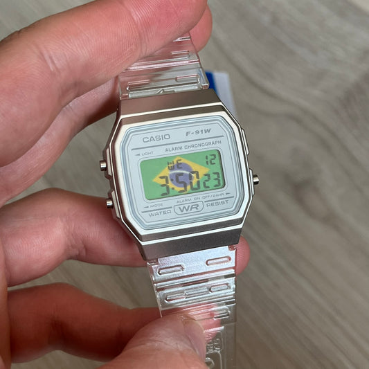 Custom Casio F-91W Clear/Transparent digital watch featuring a Brazil Flag filter screen. Slim 8.5 mm profile, lightweight 21 g build and flexible bio-based resin band ensure lasting comfort. Includes alarm, stopwatch, and microlight function for everyday functionality.