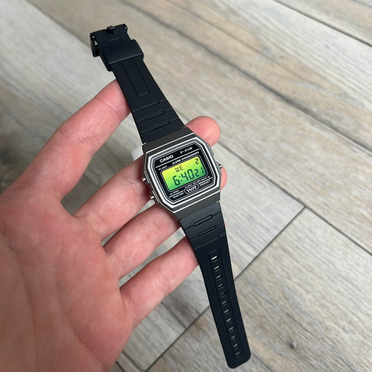 Custom Casio F-91W Black and silver digital watch featuring a Green gradient filter screen. Slim 8.5 mm profile, lightweight 21 g build and flexible bio-based resin band ensure lasting comfort. Includes alarm, stopwatch, and microlight function for everyday functionality.