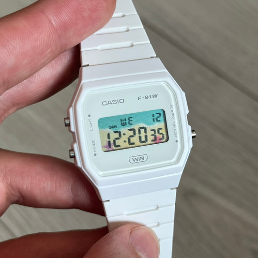 Custom Casio F-91W White digital watch featuring a Sandy beach filter screen. Slim 8.5 mm profile, lightweight 21 g build and flexible bio-based resin band ensure lasting comfort. Includes alarm, stopwatch, and microlight function for everyday functionality.