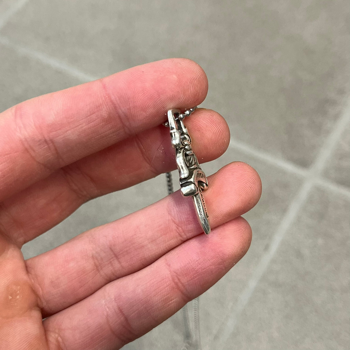 Chrome Hearts #5 Keychain Dagger Necklace crafted from .925 silver, featuring the brand’s signature double-sided dagger design with “Chrome” on the guard and “Hearts” on the blade. Comes on a stainless steel ball chain (non-CH). Square bail for chain attachment, the dagger was originally a keychain.