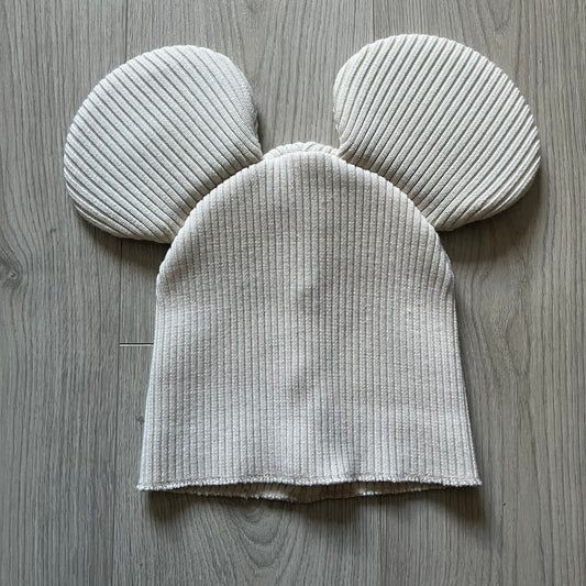Released in Autumn/Winter 2018, this Comme des Garçons beanie playfully reimagines the classic knit hat with ‘Mickey Mouse’-inspired ears. Crafted in an off-white shade with ribbed detailing, it balances fun design with signature CDG avant-garde flair. A standout seasonal accessory with a collectible edge.