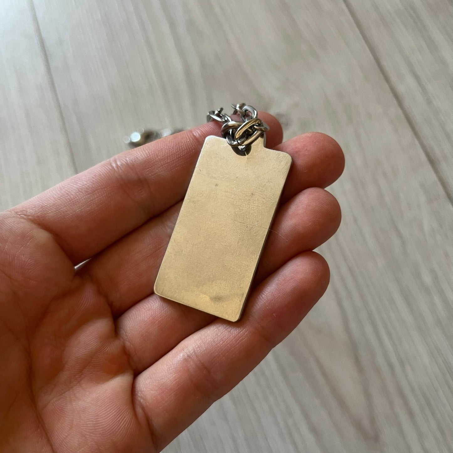 Dolce & Gabbana Propaganda Dog Tag Necklace, featuring a silver stainless steel square tag with four visible screws and the D&G logo engraved on the front. The tag hangs from a durable cable chain, combining sturdy construction with clean, industrial-inspired detailing.