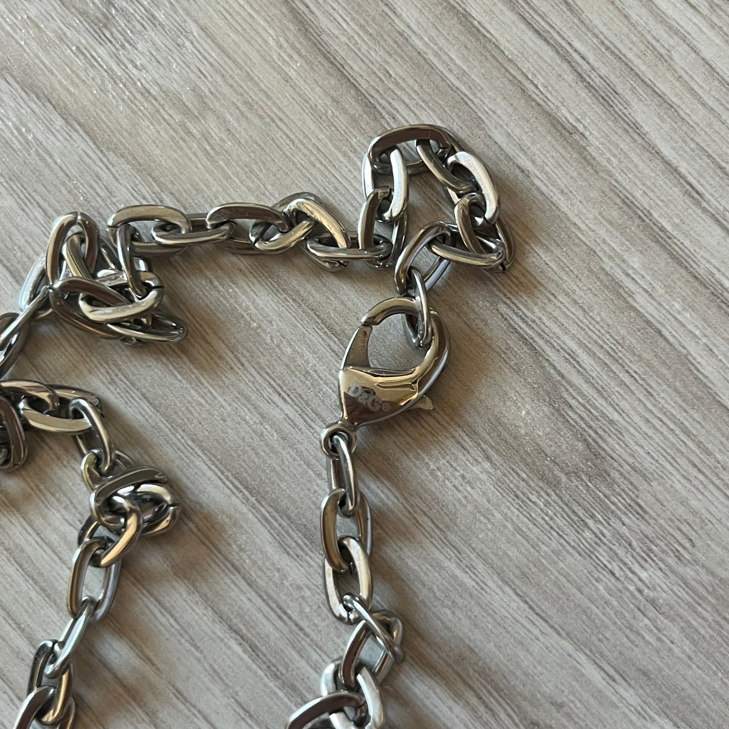 Dolce & Gabbana Propaganda Dog Tag Necklace, featuring a silver stainless steel square tag with four visible screws and the D&G logo engraved on the front. The tag hangs from a durable cable chain, combining sturdy construction with clean, industrial-inspired detailing.