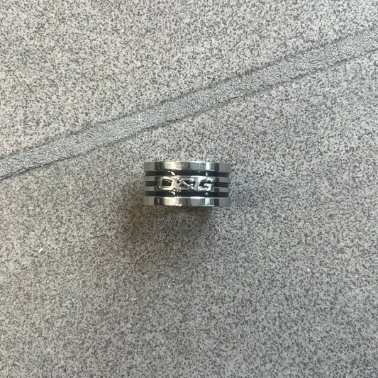 Dolce & Gabbana stainless steel ring DJ0709 in silver, featuring three subtle black engraved stripes encircling the band. The D&G logo is displayed in polished silver on top, creating a nice contrast with the dark detailing.
