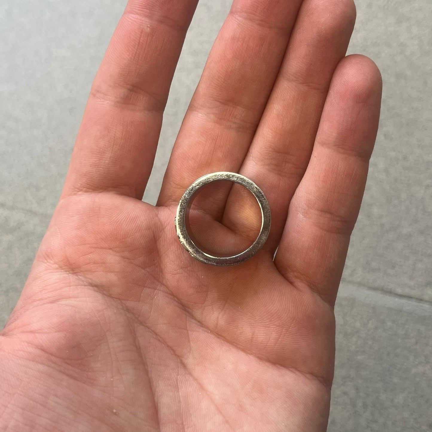 Dolce & Gabbana stainless steel ring DJ0709 in silver, featuring three subtle black engraved stripes encircling the band. The D&G logo is displayed in polished silver on top, creating a nice contrast with the dark detailing.