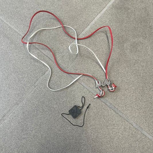 Dolce & Gabbana 2000s Red & White Strings Necklace & Bracelet is a versatile accessory featuring red and white leather cords joined with stainless steel end caps. The center is finished with a stainless steel D&G logo, while the back of the logo features a small engraved D&G mark. Designed to be worn either as a necklace or wrapped as a bracelet.