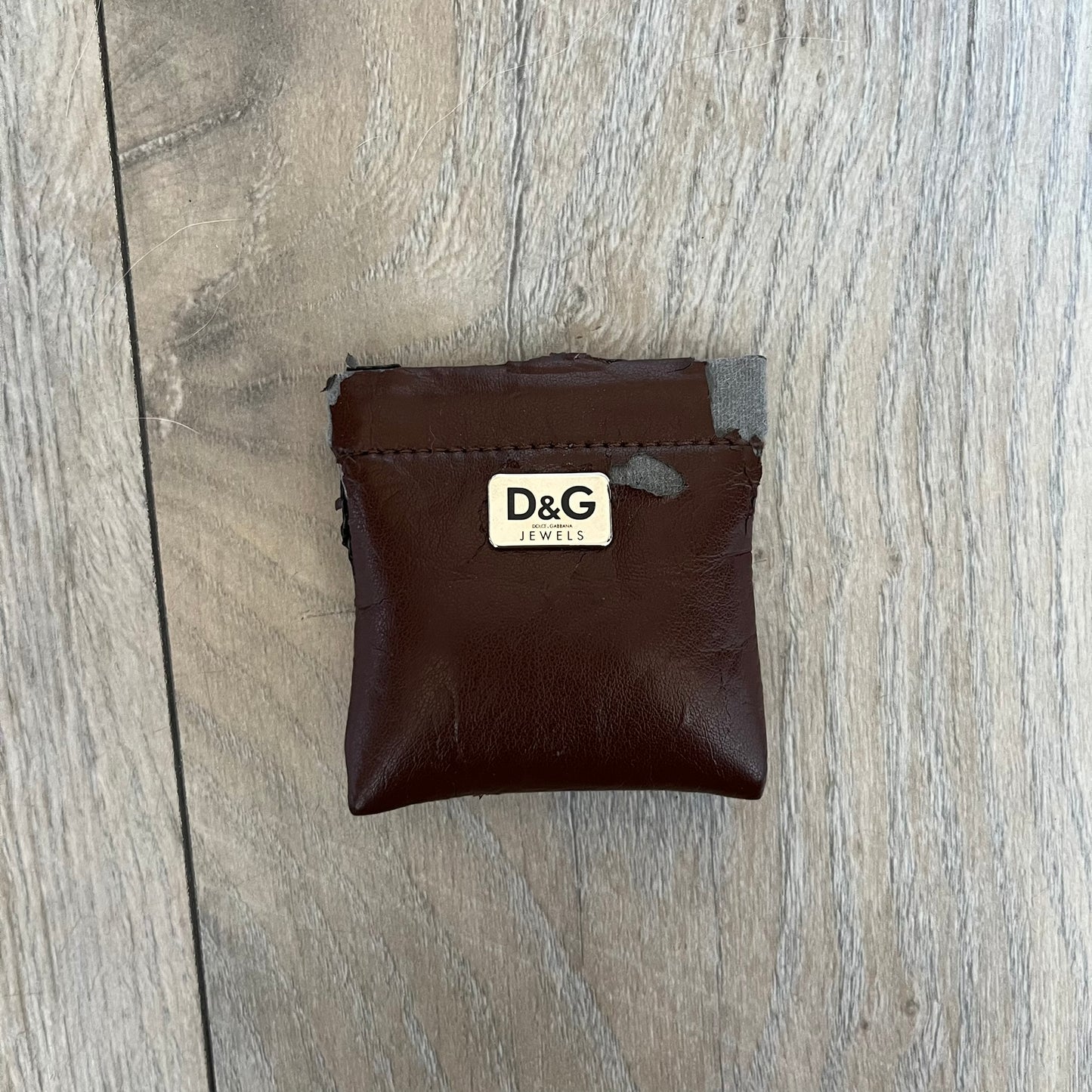Dolce & Gabbana 2000s Round D&G Logo Necklace is a chain necklace featuring a lobster clasp closure and a thick 3D circular pendant with cut-out center and D&G logo in the middle. The pendant connector is embellished with crystal detailing. The necklace comes with a brown Dolce & Gabbana dust bag.