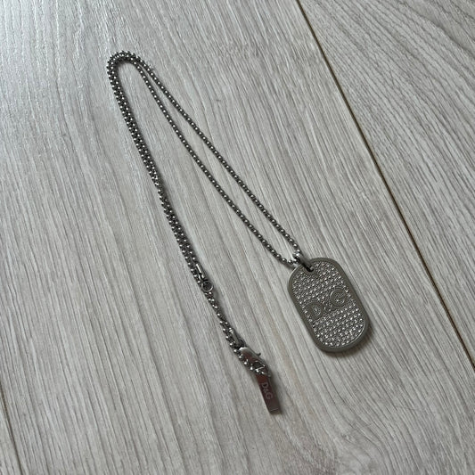 Dog tag necklace on a wooden surface