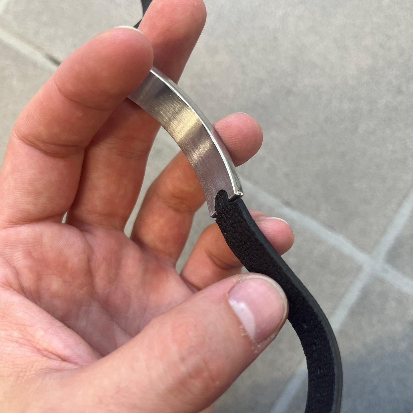 Dolce & Gabbana DJ0574 Black Stone Bracelet is a black leather bracelet featuring a stainless steel central plaque. The plaque includes a rectangular black stone detail with an engraved D&G logo on the right side. The clasp is also engraved with the D&G logo, completing the minimal design.