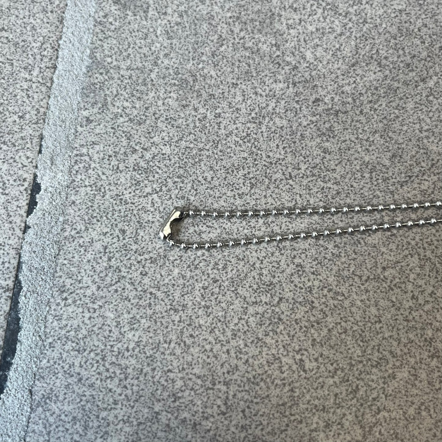 Dolce & Gabbana 2000s Credit Card Necklace (DJ0772) is a rare stainless steel necklace featuring a credit card-shaped pendant. The pendant includes a large raised D&G logo, an engraved D&G logo, and embossed numbers inspired by a real credit card. The chain is not D&G - it's a basic steel ball chain, only the pendant is from Dolce.
