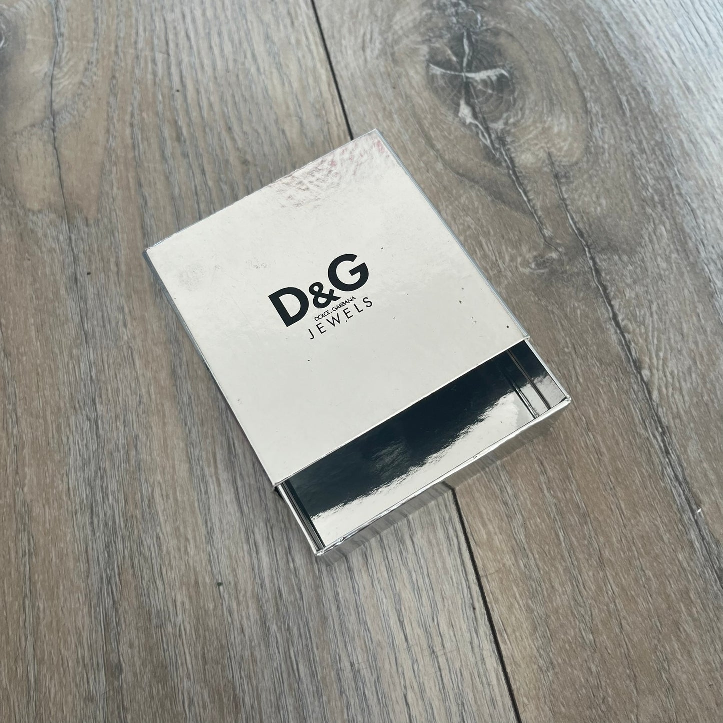 Dolce & Gabbana “D&G IS MY MENTOR” Bracelet is a gold leather bracelet with a glossy finish. The bracelet features line cutout detailing throughout and fastens with two snap-button closures on the back. A gold-tone metal plaque on the front is engraved with “D&G IS MY MENTOR.” The bracelet comes with its original box.