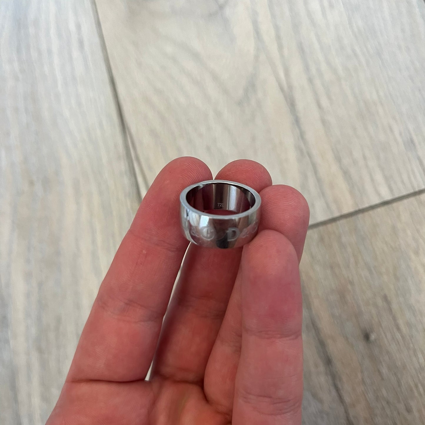 Dolce & Gabbana Logo Repeat Ring is a stainless steel ring featuring repeating engraved D&G logos around the entire band. The design is minimal and clean, focusing on subtle branded detailing and polished metal construction.