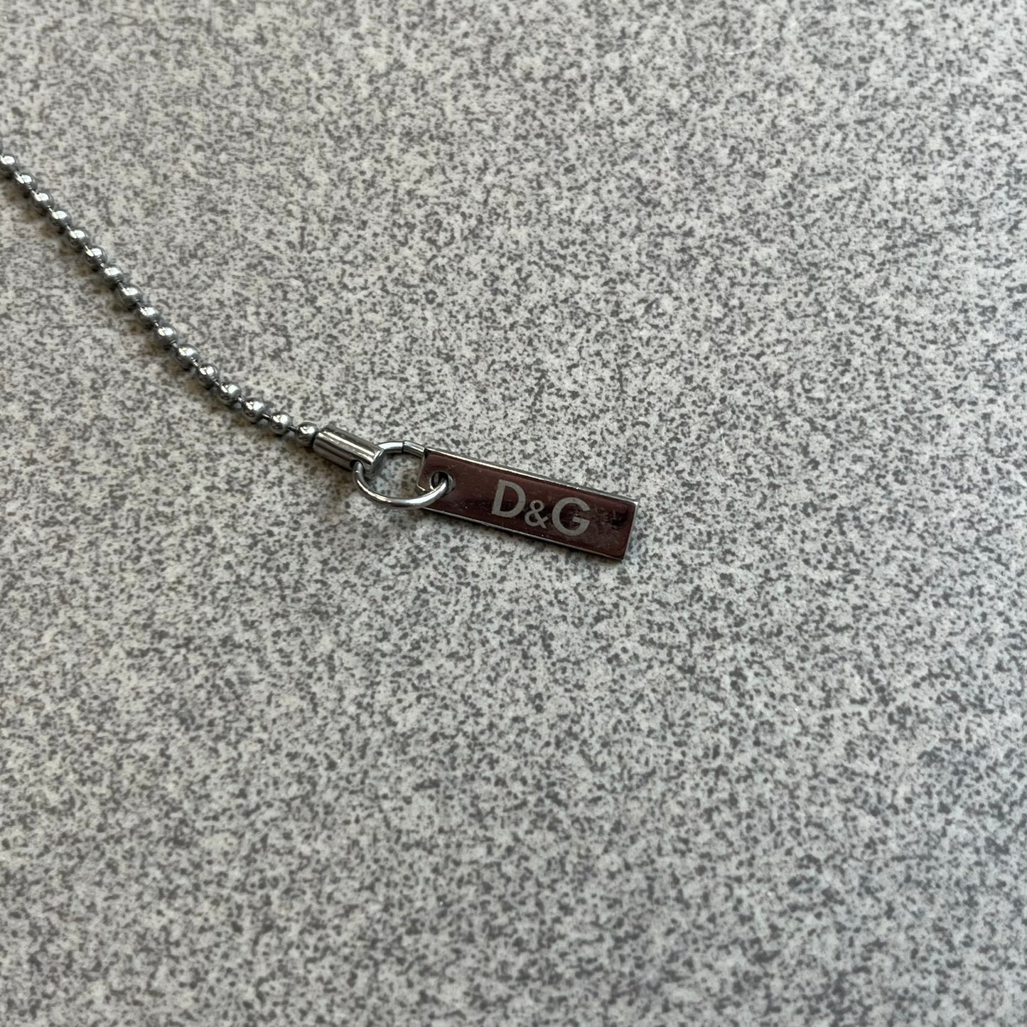 Dolce & Gabbana Pearl Red/Black Rosary Necklace from the 2000's era. The necklace features a silver-tone metal cross with a D&G logo, connected via a black leather link to a metal chain with alternating red and black pearl-style beads. Rosary-style construction with mixed materials including metal, leather, and resin pearls. 