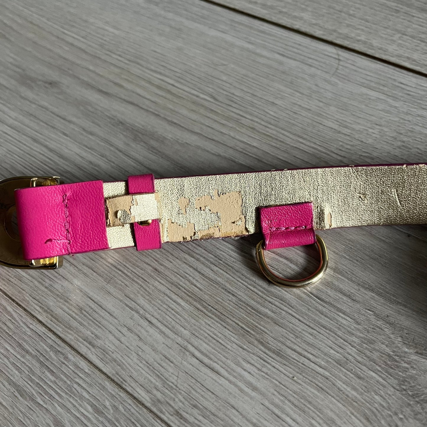 This Dolce & Gabbana Belt combines a slim pink design with a statement D&G buckle framed in gold and accented by visible screws. The inner side of the belt features a gold finish, highlighting the brand’s attention to material contrast. A classic Italian accessory crafted with detailed hardware.