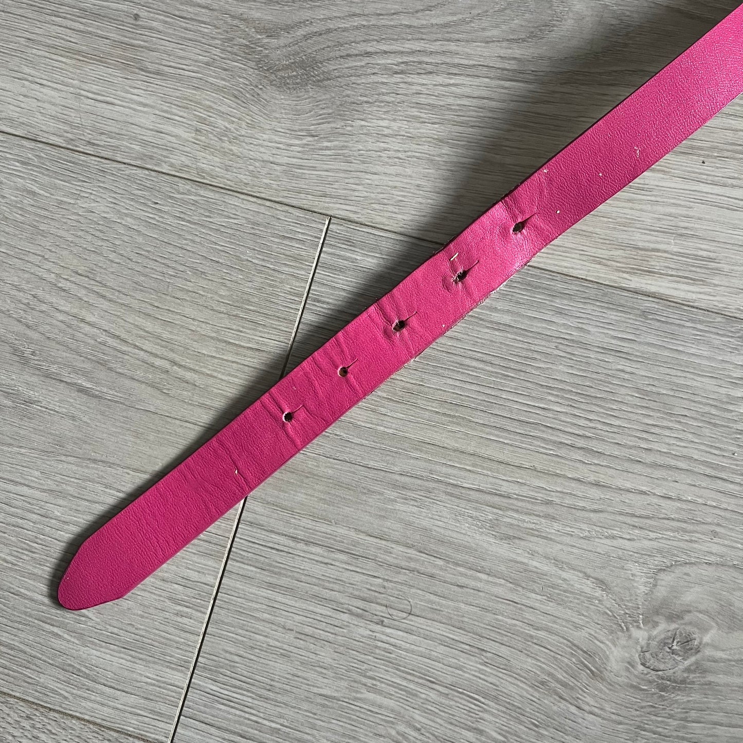 This Dolce & Gabbana Belt combines a slim pink design with a statement D&G buckle framed in gold and accented by visible screws. The inner side of the belt features a gold finish, highlighting the brand’s attention to material contrast. A classic Italian accessory crafted with detailed hardware.