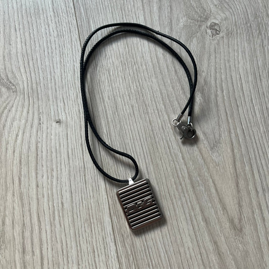 Necklace with a square pendant on a wooden surface
