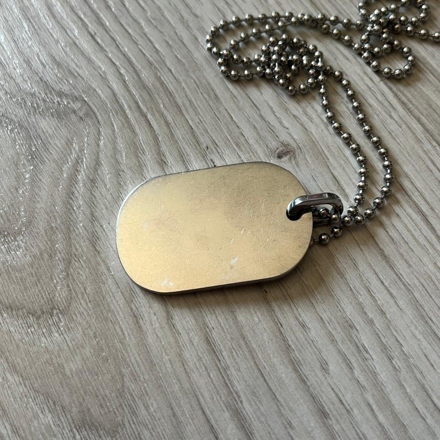Dolce & Gabbana sniper dog tag necklace in silver-tone stainless steel, featuring a cross resembling a sniper crosshair and a bold D&G logo on top. Completed with a classic ball chain, it merges military-inspired aesthetics with luxury branding. A statement accessory that brings edgy, modern design to any outfit.