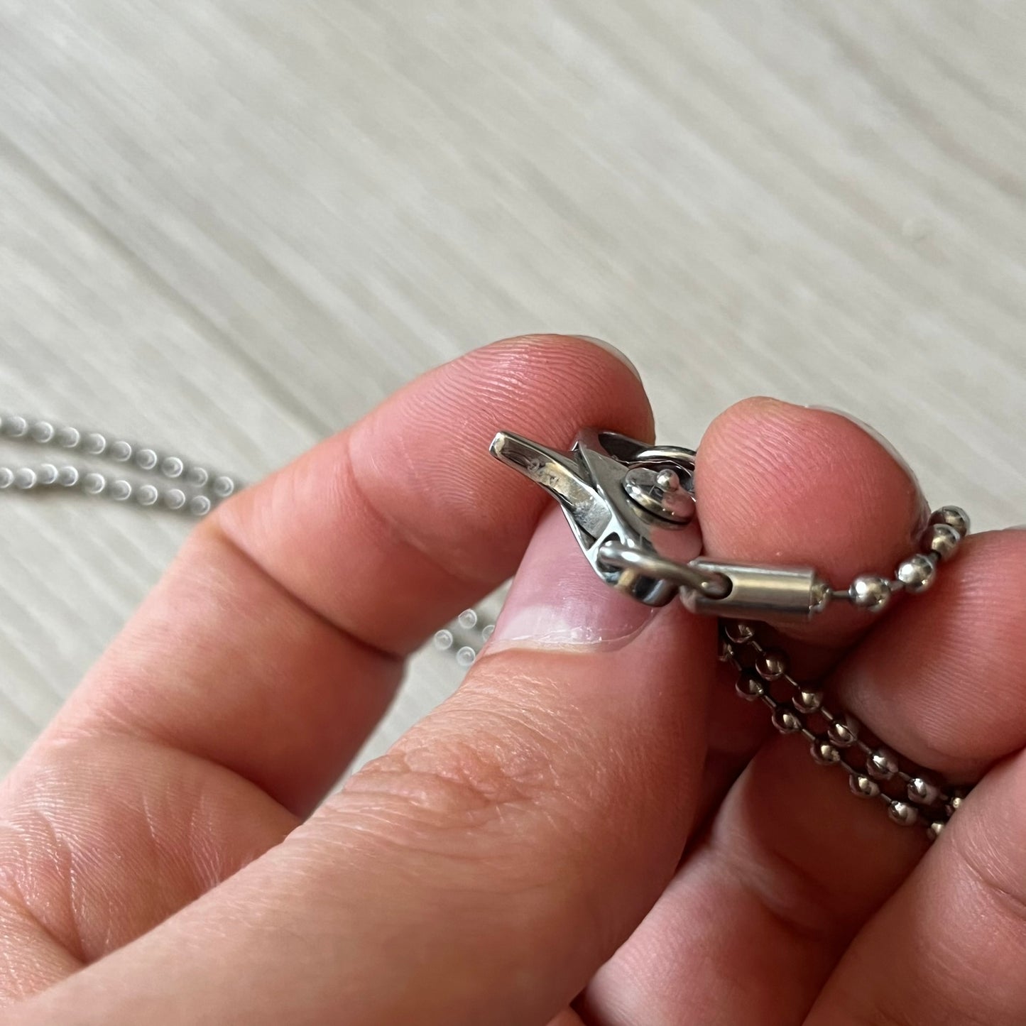 Dolce & Gabbana sniper dog tag necklace in silver-tone stainless steel, featuring a cross resembling a sniper crosshair and a bold D&G logo on top. Completed with a classic ball chain, it merges military-inspired aesthetics with luxury branding. A statement accessory that brings edgy, modern design to any outfit.
