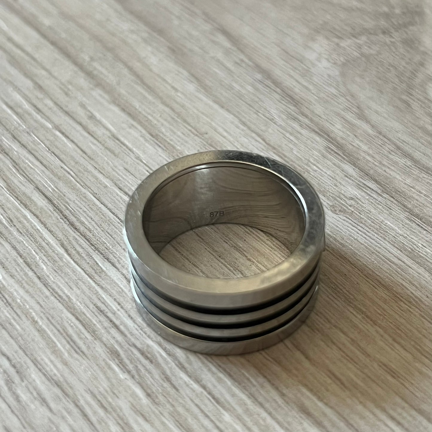 Dolce & Gabbana stainless steel ring DJ0709 in silver, featuring three subtle black engraved stripes encircling the band. The D&G logo is displayed in polished silver on top, creating a nice contrast with the dark detailing.