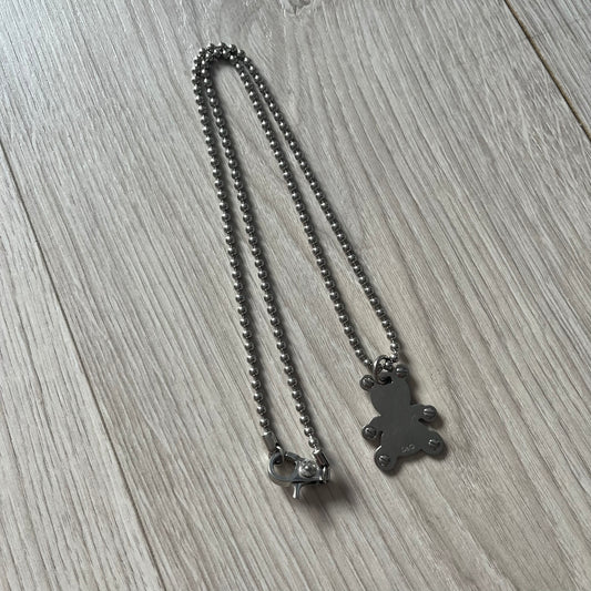 Metallic necklace with a pendant on a wooden surface