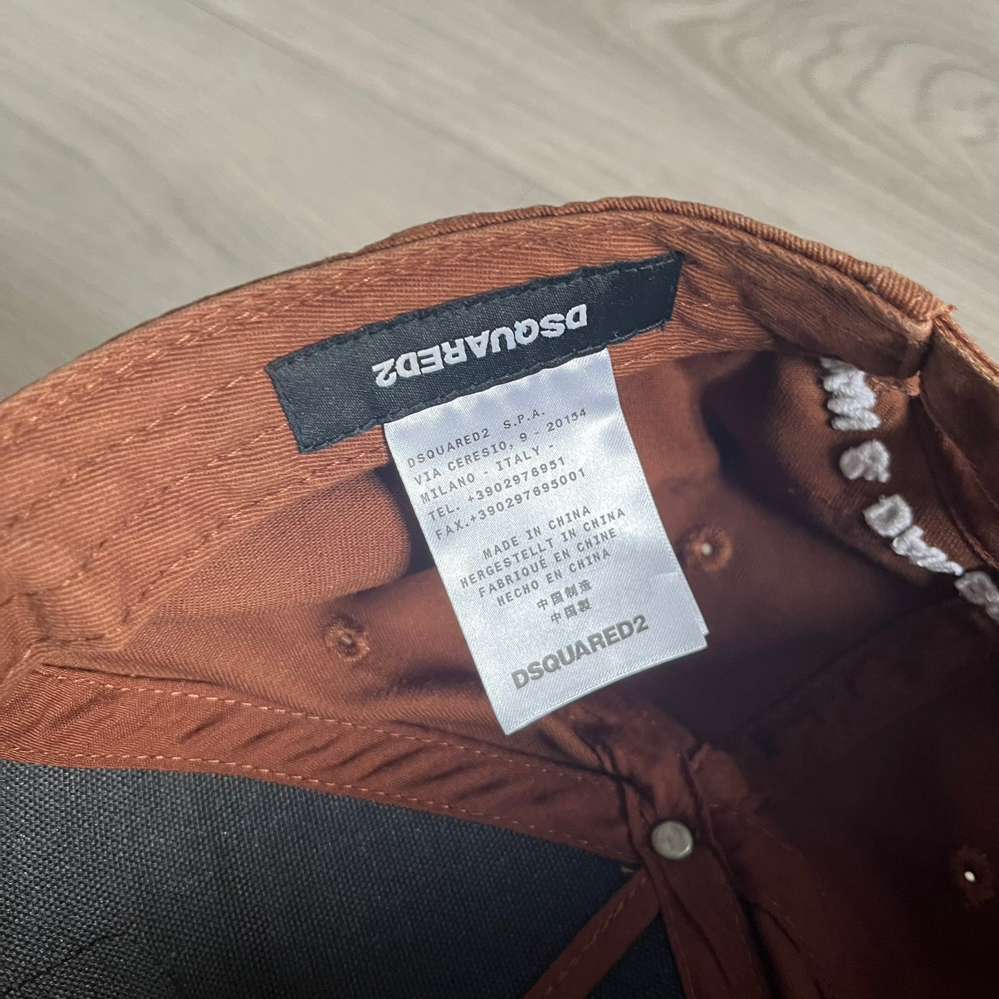 Brown jacket with Dsquared2 label on a wooden surface