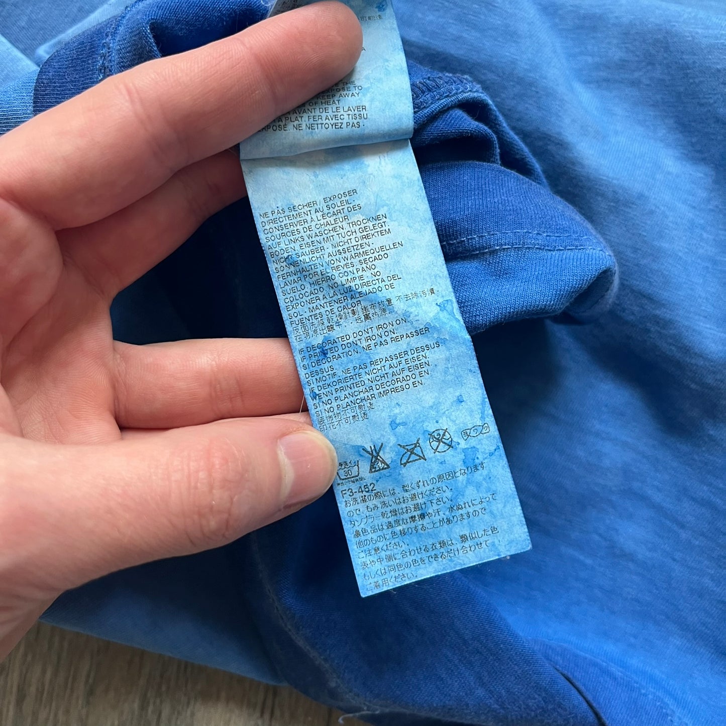 Dsquared2 Blue Rebel Monkey T-Shirt from the Spring/Summer 2015 collection. Crafted in Italy from cotton, the tee features a washed blue finish with darker tonal hems and a lighter faded center. The front displays a large stylized monkey graphic in yellow, white, red, and black, with text reading “Monkey Me… Dsquared2 Motherfuc…” incorporated into the design.