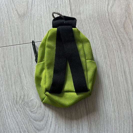 Eastpak’s Mini Green Backpack is a collectible-sized accessory with elastic pack straps. While it can be used as a tiny bag, it’s more often seen as a novelty piece or keychain. A playful twist on the brand’s iconic design.