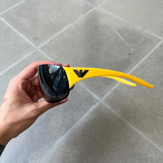 Emporio Armani 2000's Shield Yellow Sunglasses feature a black shield-style front with a single continuous lens and yellow temples. The temples have black Emporio Armani eagle logos, with model EA 9242/S SVG95. Made in Italy and comes with the original red case.