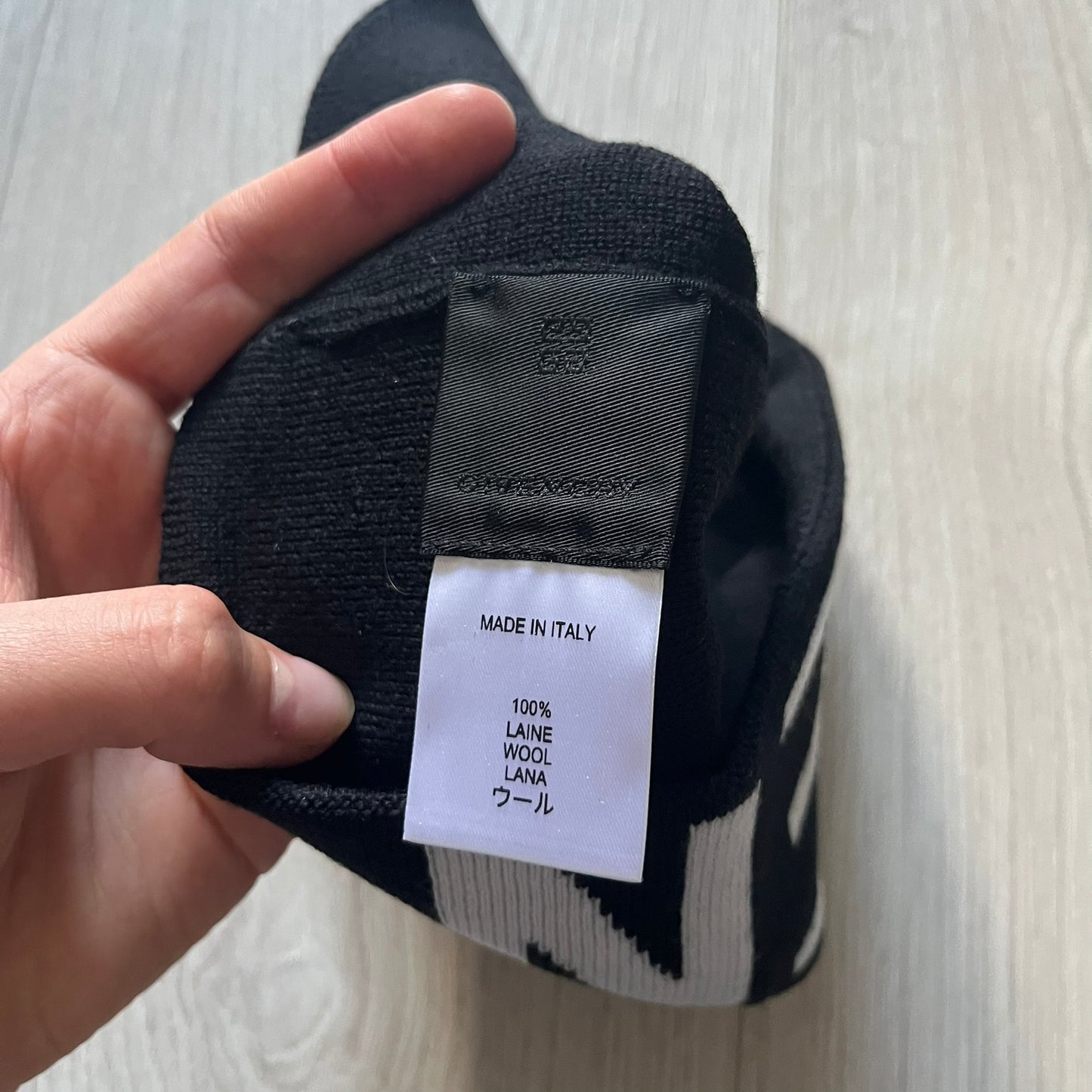 Black Givenchy Jacquard beanie made from 100% wool and crafted in Italy. Features the white contrasting logo around the rolled brim, splitting “GIVE” and “NCHY” across the hem. Premium construction with a soft, comfortable fit.