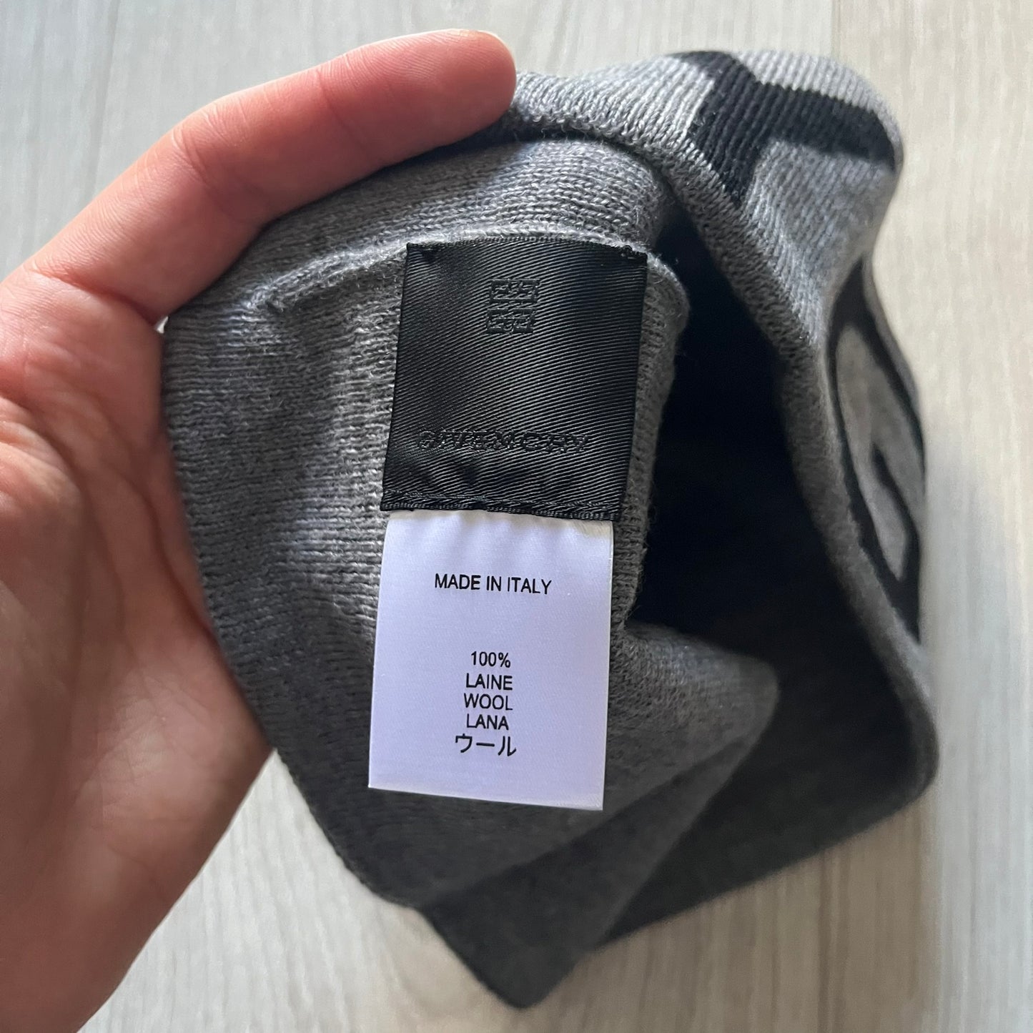Gray Givenchy Jacquard beanie made from 100% wool and crafted in Italy. Features the black contrasting logo around the rolled brim, splitting “GIVE” and “NCHY” across the hem. Premium construction with a soft, comfortable fit.