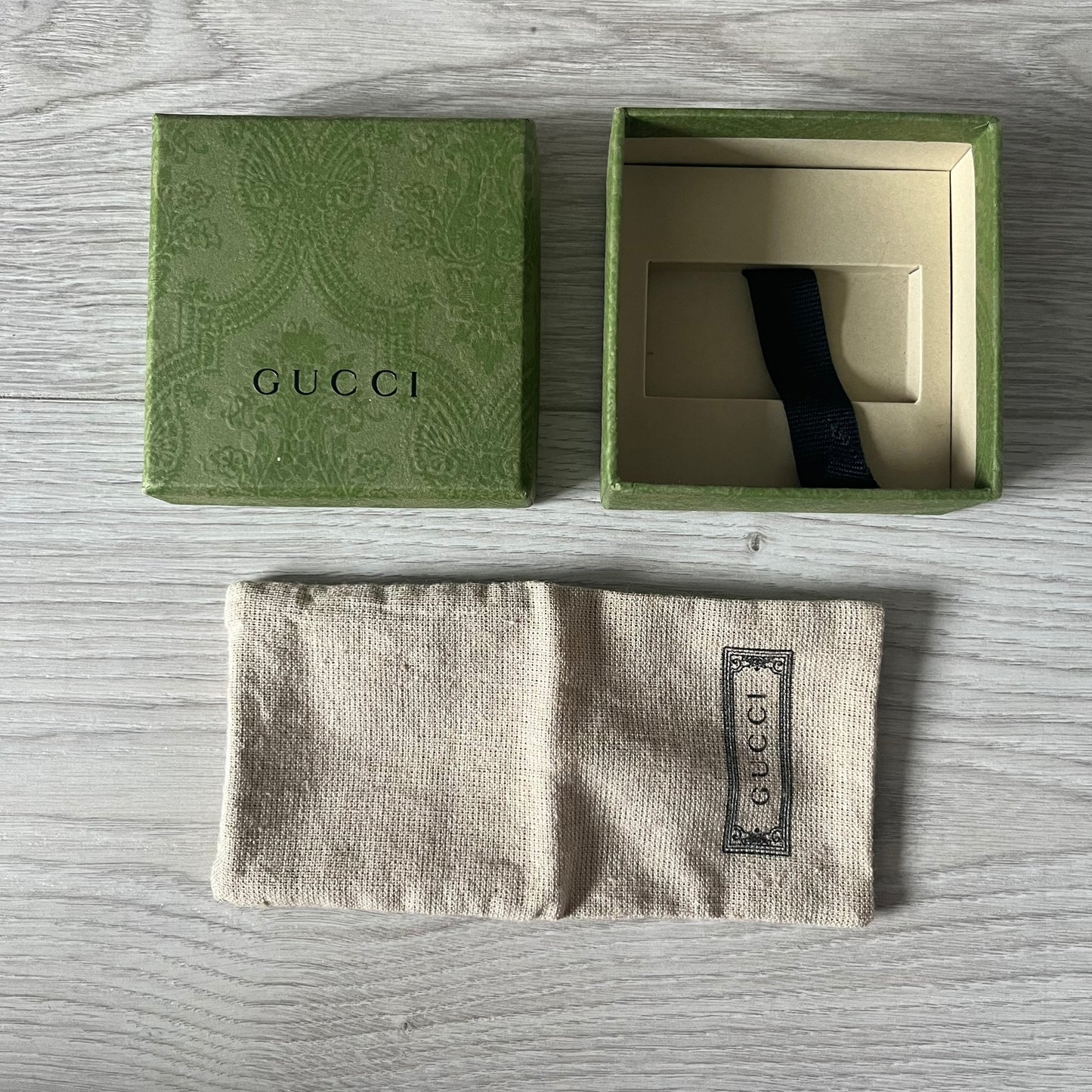 Gucci wallet and box on a wooden surface
