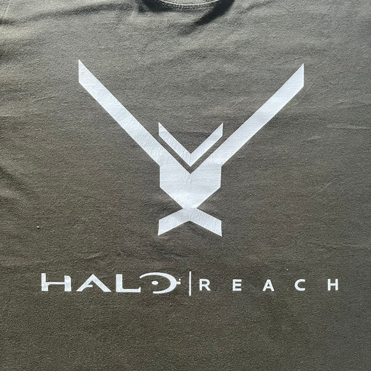 Khaki Halo Reach tee on a Sol’s blank featuring the Noble Team emblem in white on the front and the Halo Reach logo beneath. Small Xbox 360 logo embroidered under the back collar. A classic collectible for fans of the iconic game series.