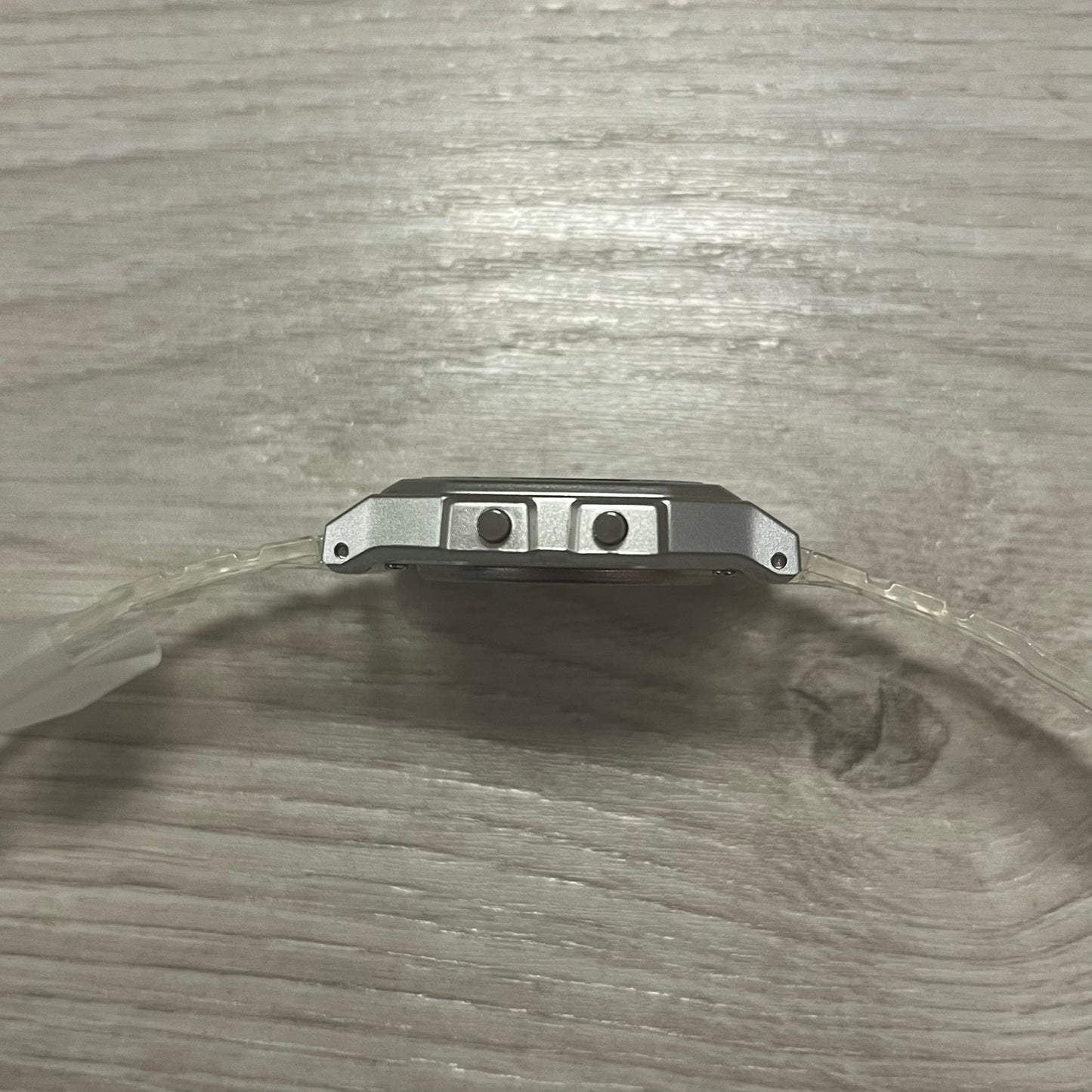 Metal bracket with two screws on a wooden surface