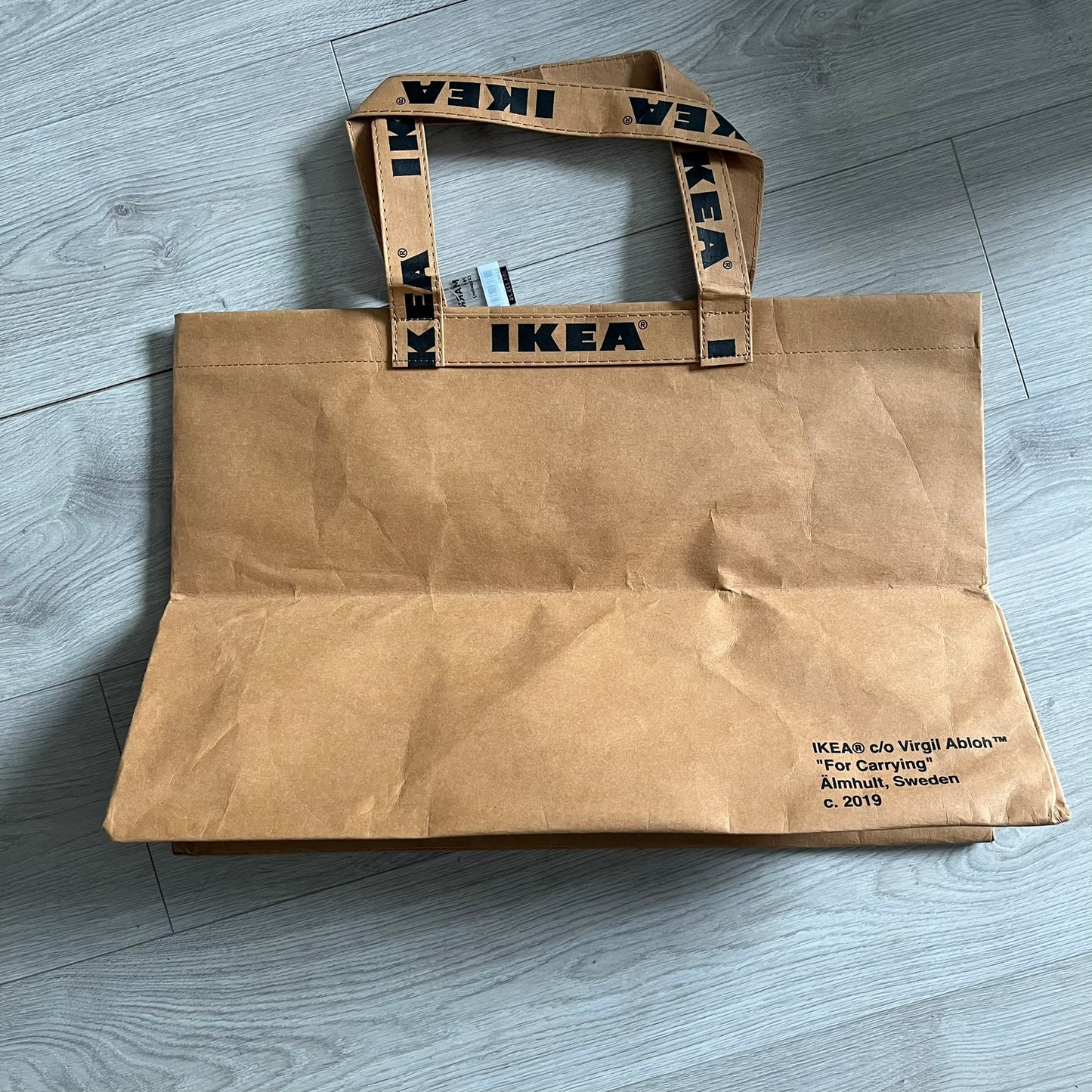Ikea x Virgil Abloh Markerad "Sculpture" Carrier Bag from FW19 reimagines the iconic blue Frakta tote in reinforced brown paper. Embellished with Abloh’s signature quotation marks, the “SCULPTURE” print transforms a utilitarian object into conceptual design. A collectible symbol of functional art and everyday irony.